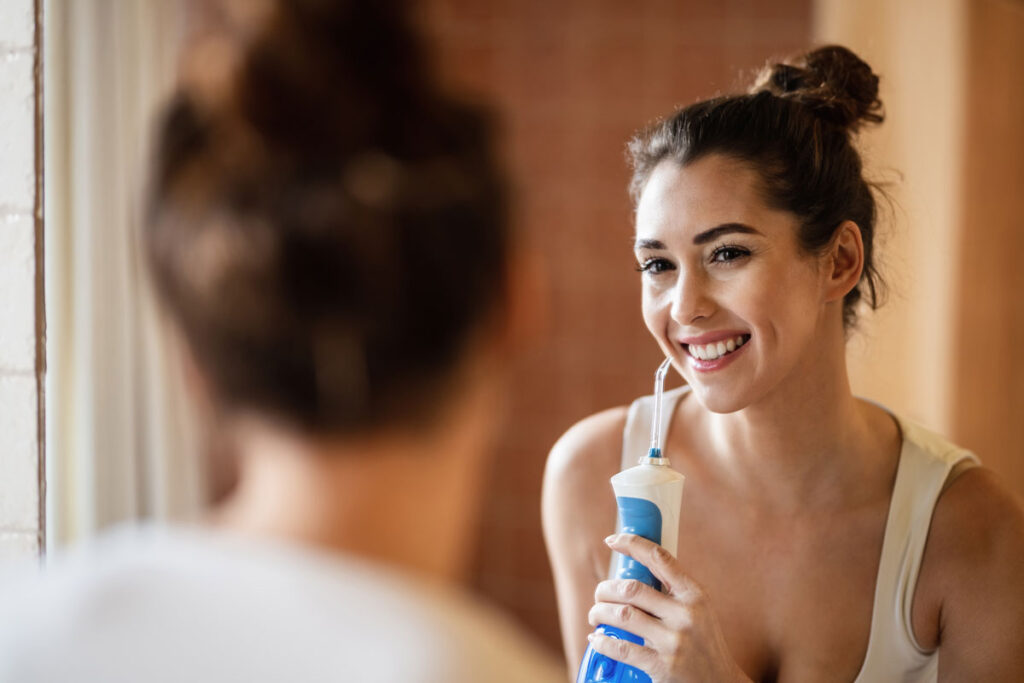 Smile Dental Partners patient using a water flosser
